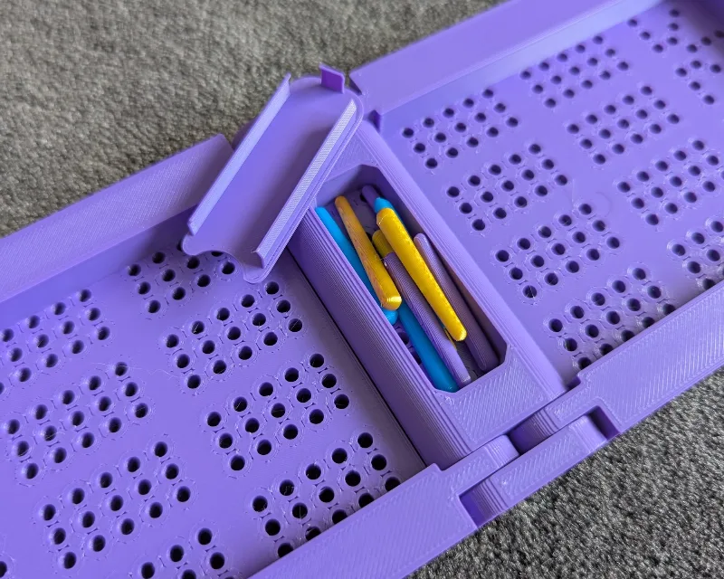 Pegs and storage cap for folding cribbage board