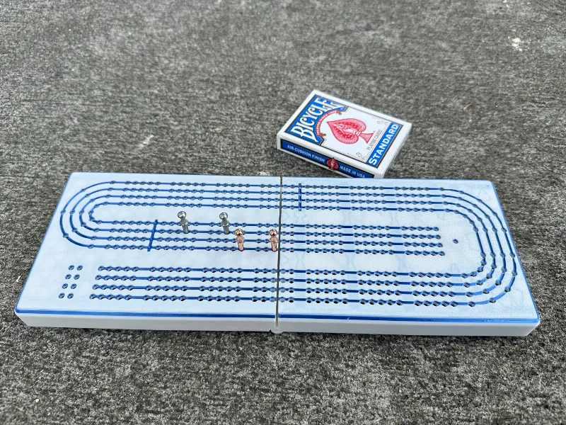 Four player hinged cribbage board with pegs